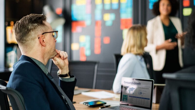 solo founder reviewing B2B sales notes at laptop during strategy session