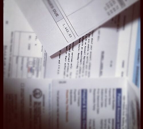 Medical bills stacked next to health insurance documents showing cost comparison for self-employed founders