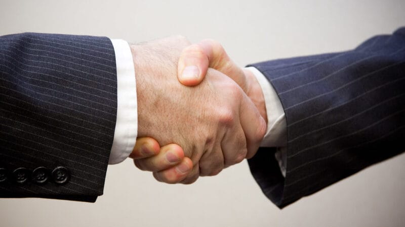 business deal handshake closing a small business acquisition in a recession