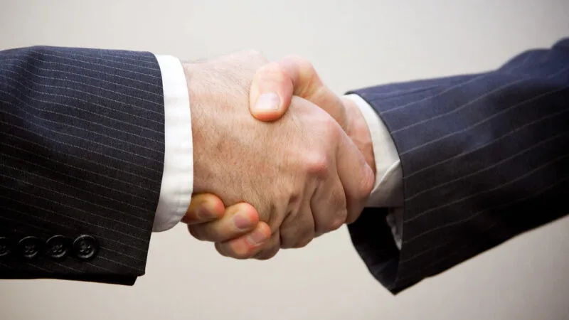 business deal handshake closing a small business acquisition in a recession